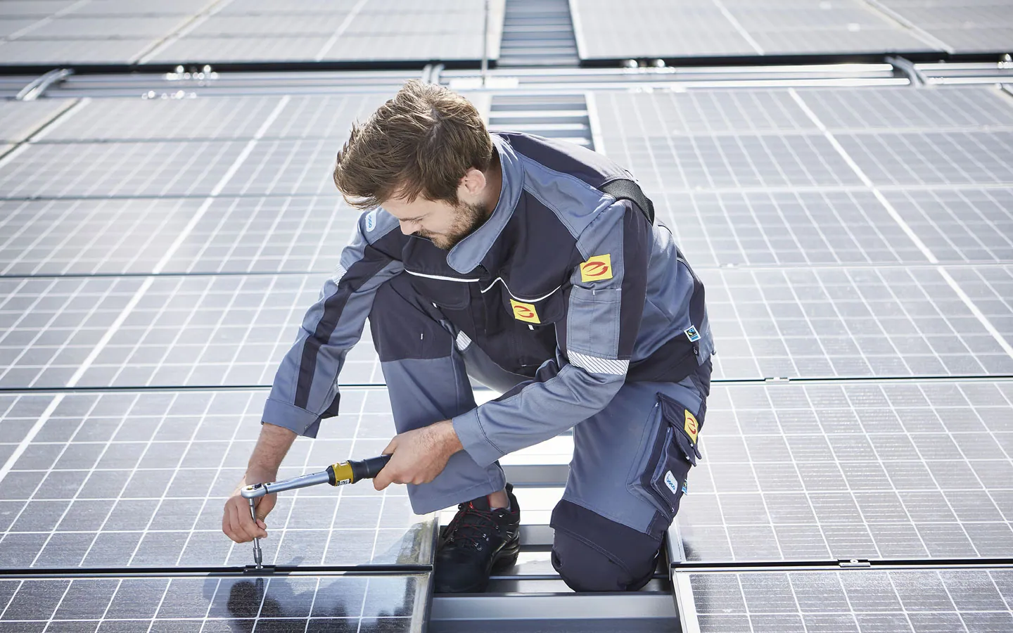 E-CHECK E-Mobilität - Mitarbeiter montiert auf dem Dach die neuen Solarmodule &middot; ARNOLD Elektrotechnik